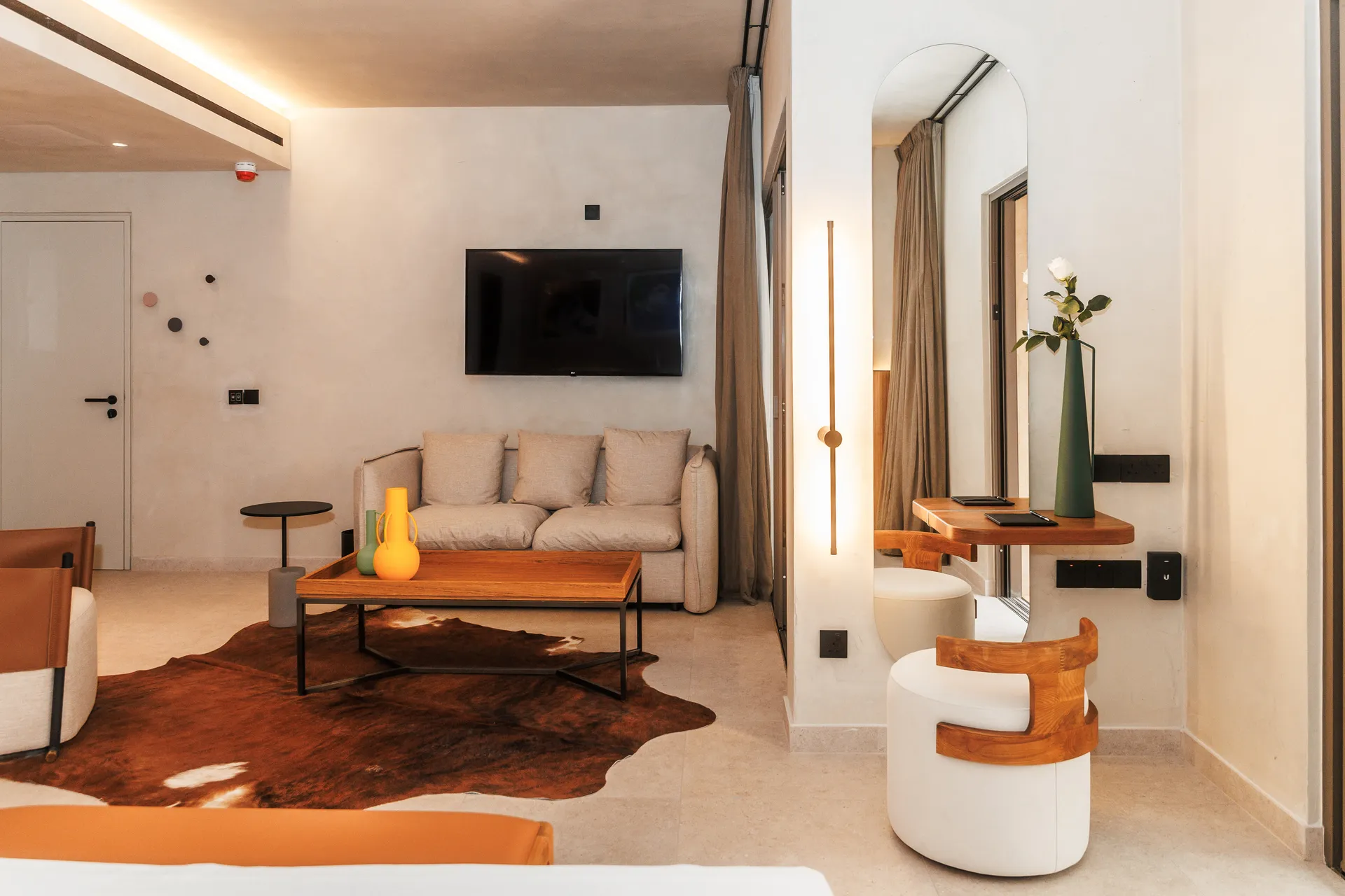Modern living room with beige sofa and animal hide rug.