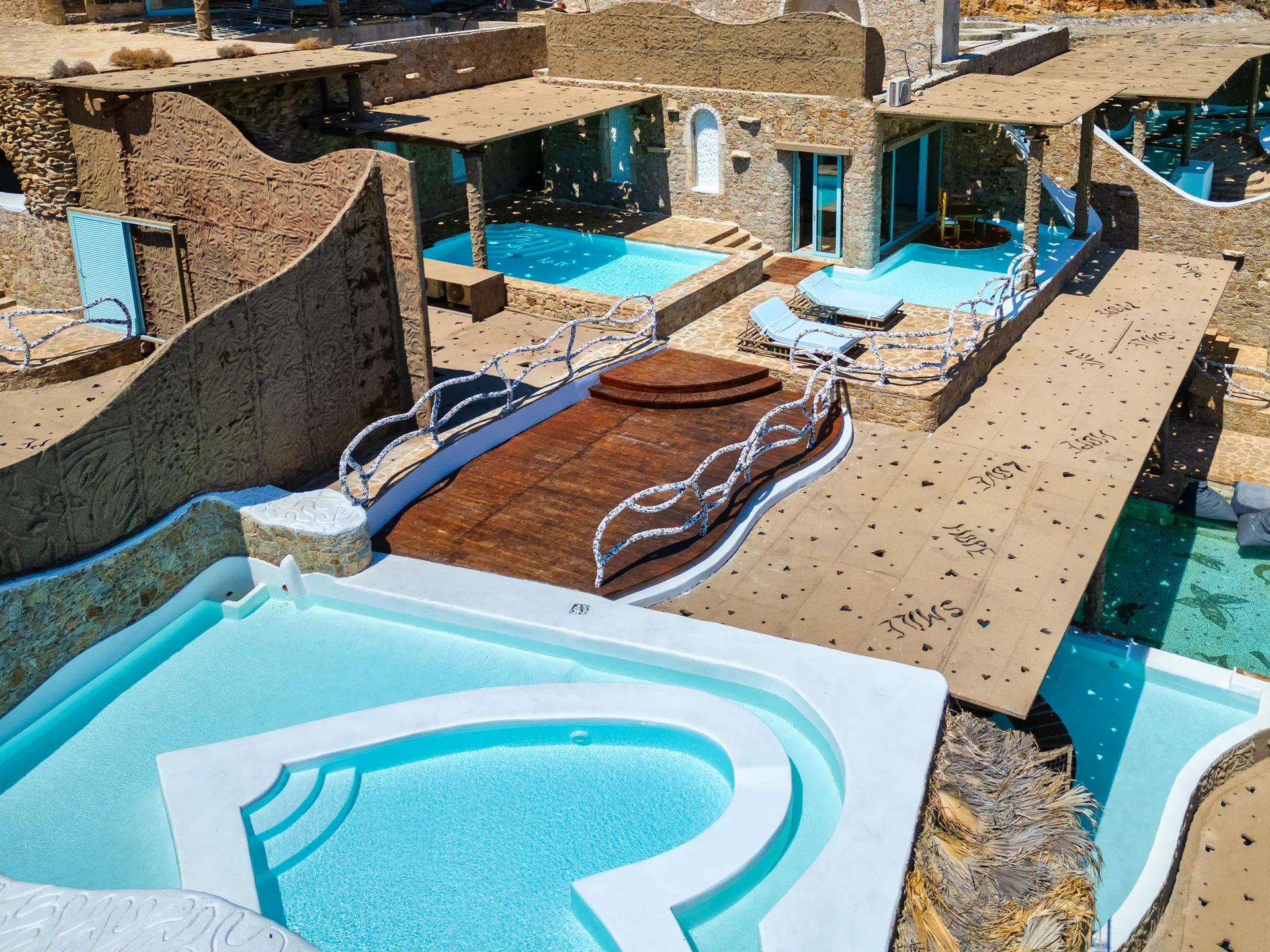 Luxurious villas with private pools and sunbathing areas.