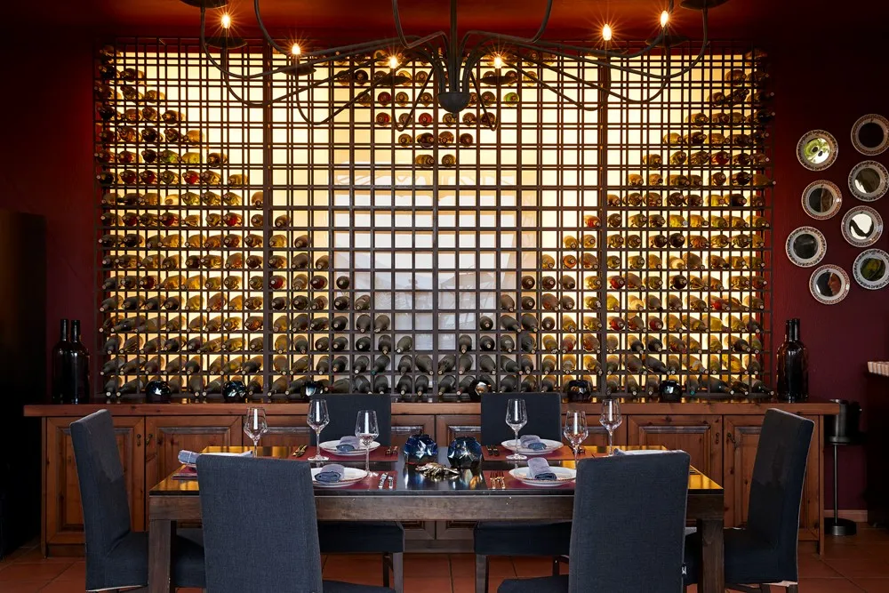 Elegant dining area with a modern wine display wall and warm lighting.