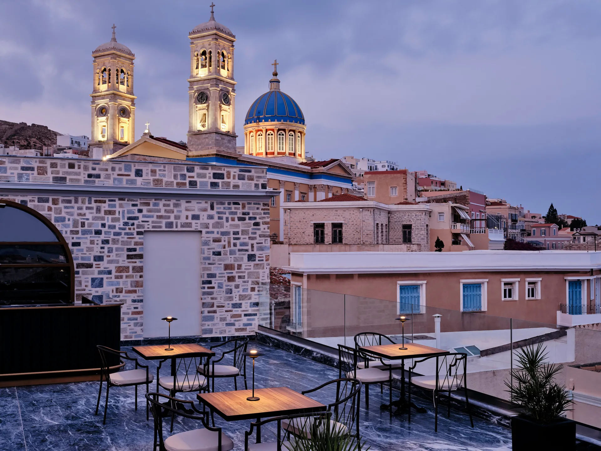Rooftop dining with a view of a historic church at dusk.