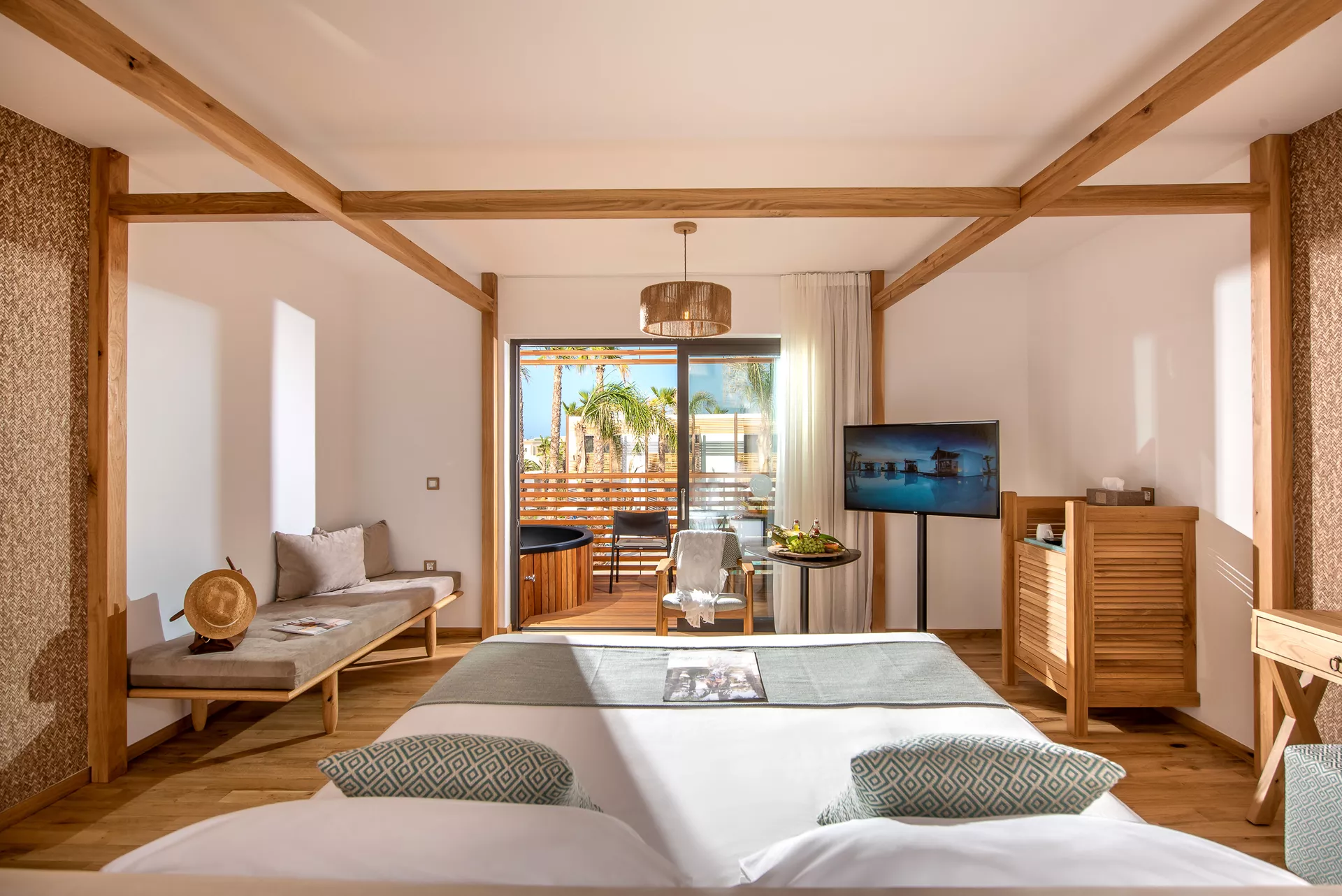 Modern bedroom with a large bed and a view of a cozy balcony.
