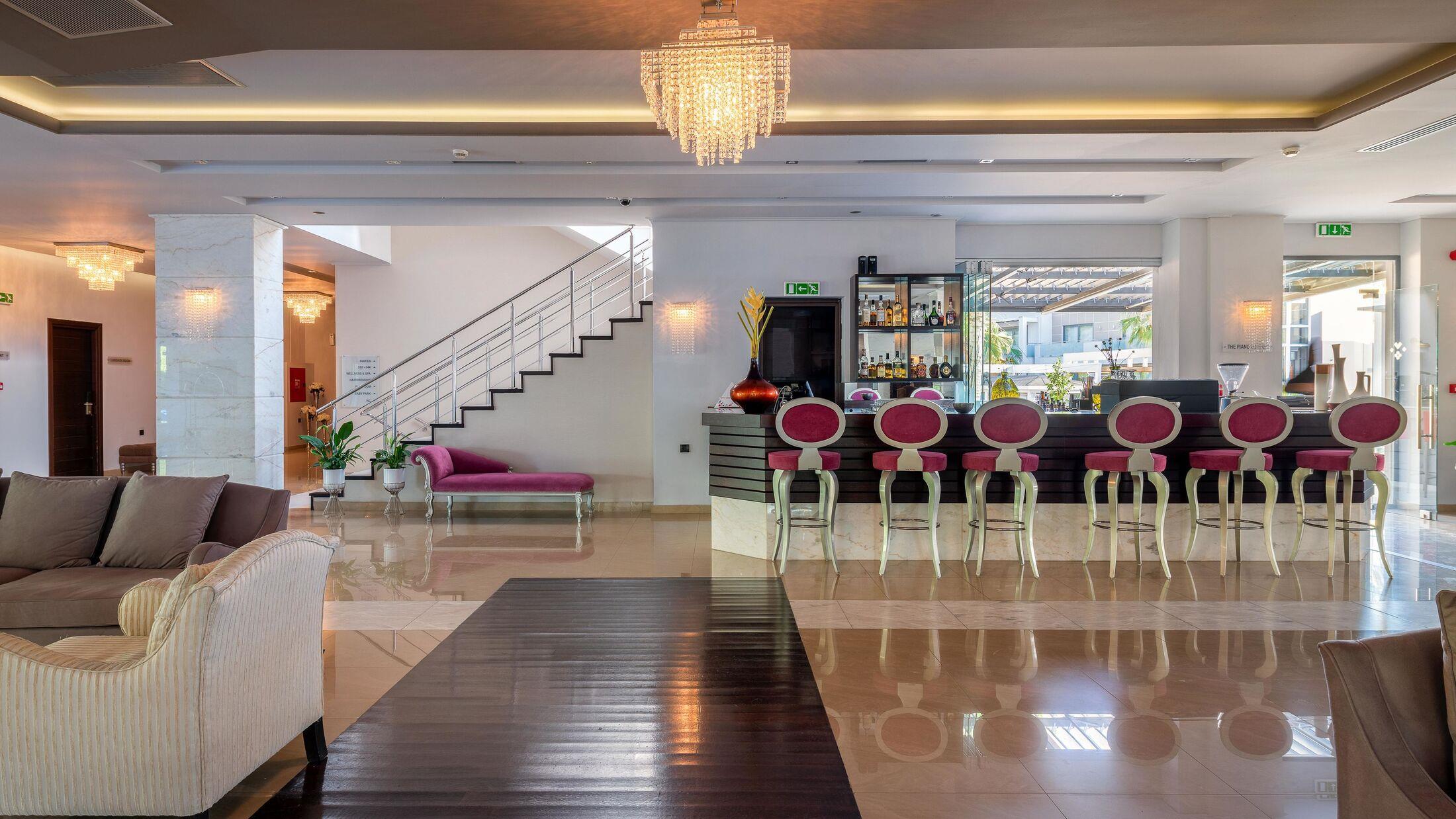 Elegant modern living room with bar seating and chandelier.
