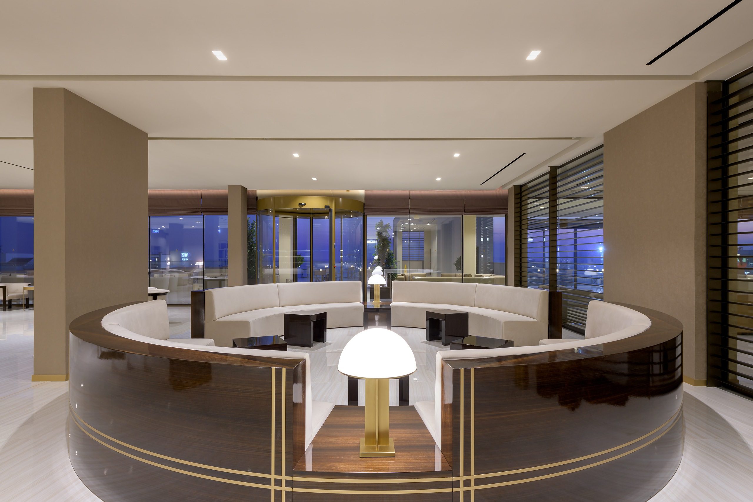 Modern circular lounge with panoramic city views and elegant lighting.
