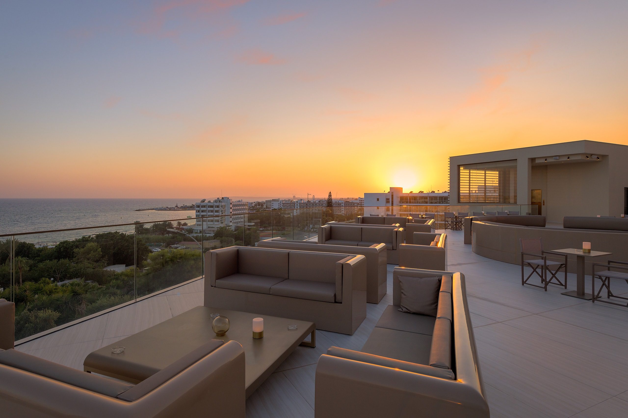 Modern rooftop lounge with sunset views and comfortable seating.