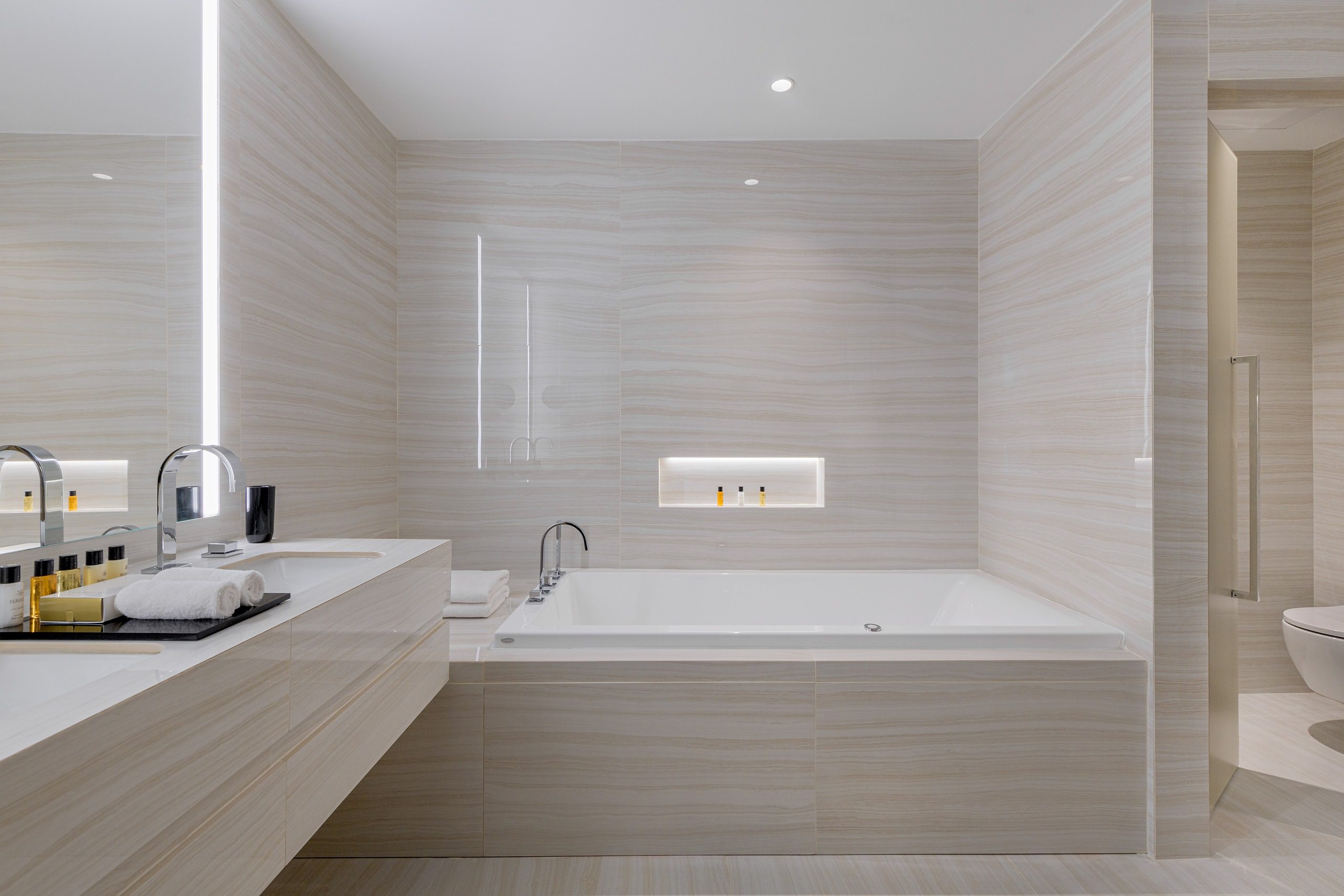 Minimalist bathroom with a modern bathtub and soft lighting.