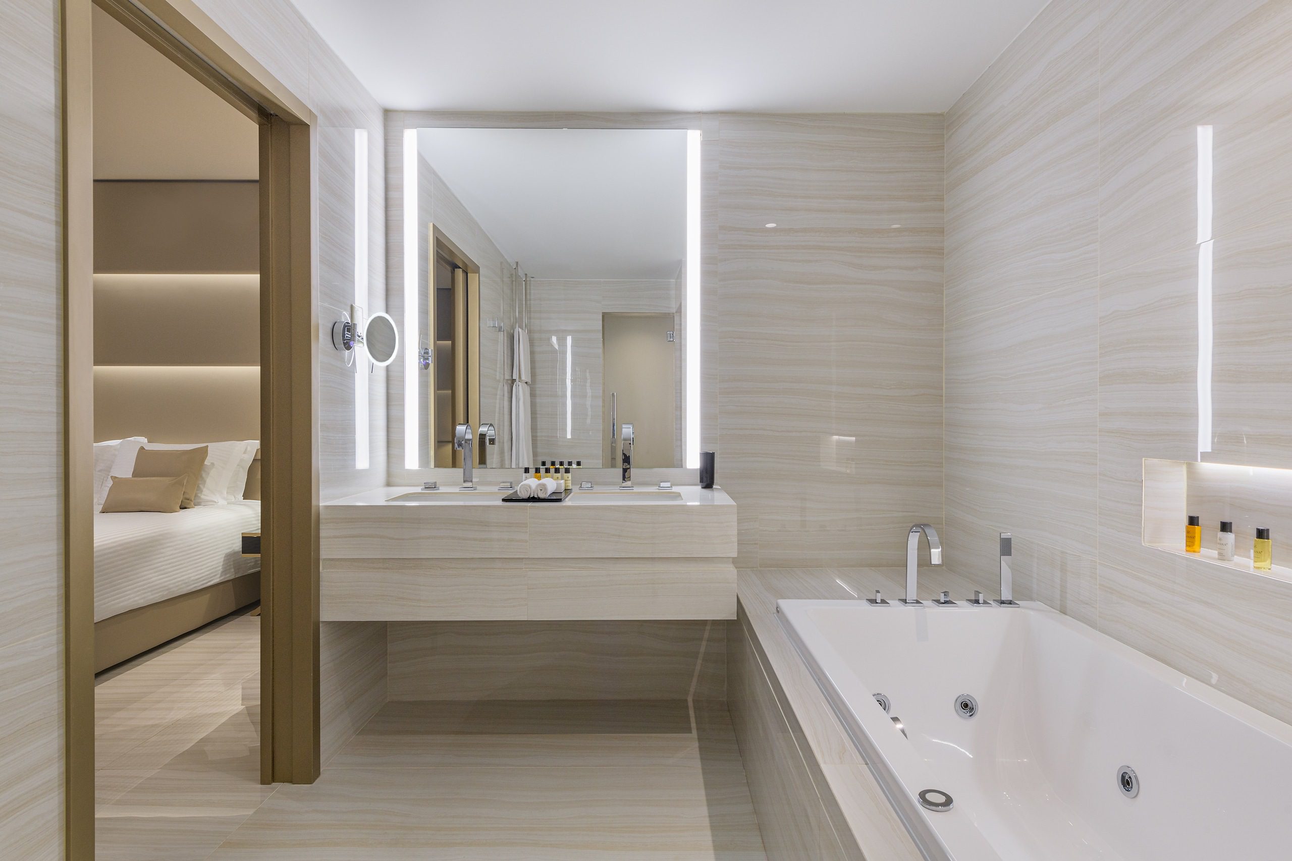 Modern bathroom with a large mirror, sink, and bathtub.