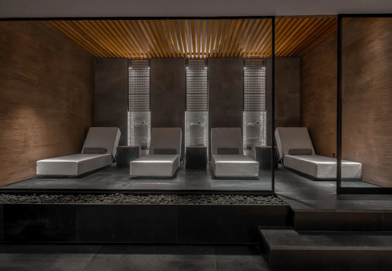 Luxurious modern sauna with wooden ceiling and sleek benches.