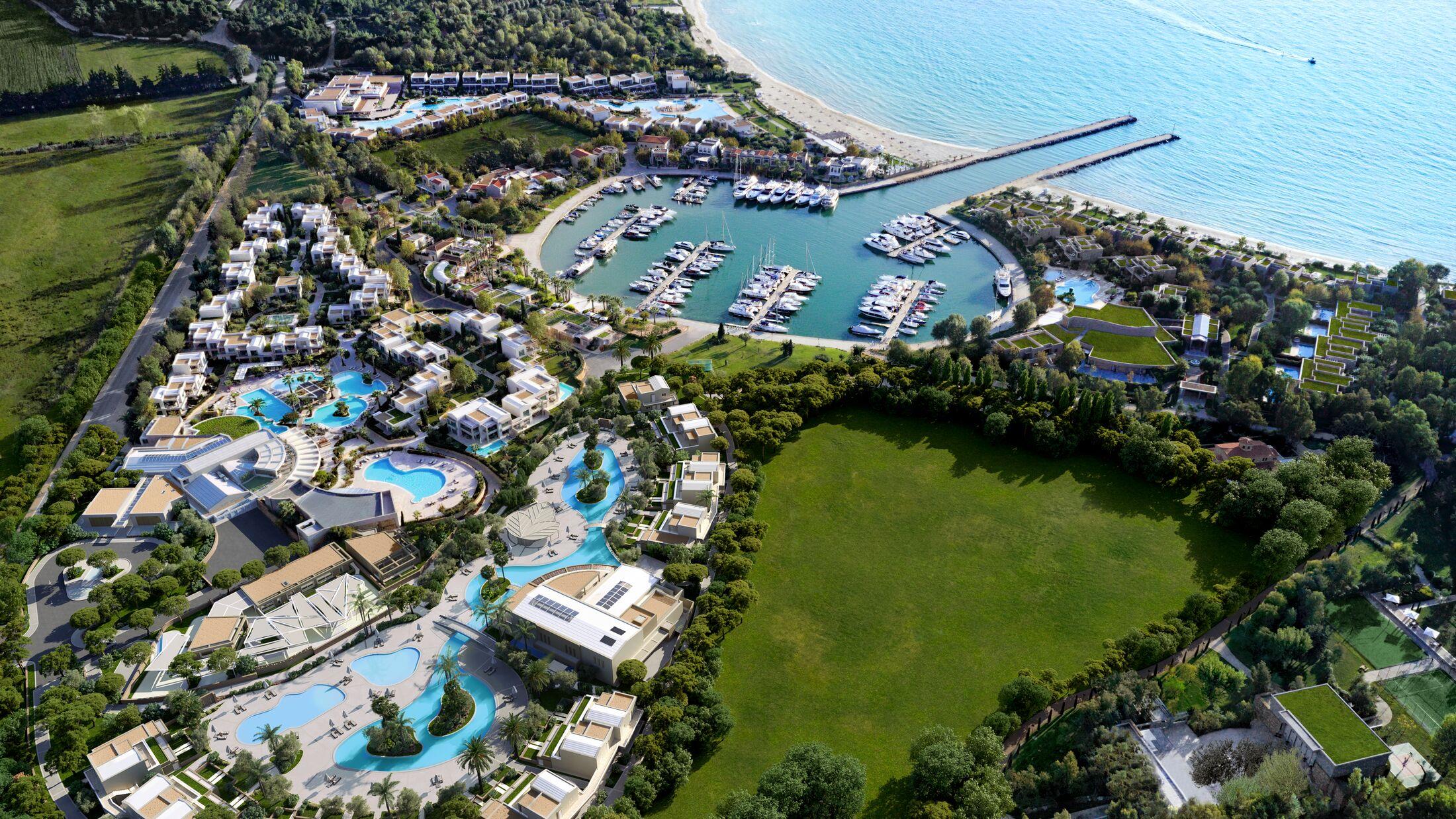 Aerial view of a coastal marina with yachts and surrounding greenery.