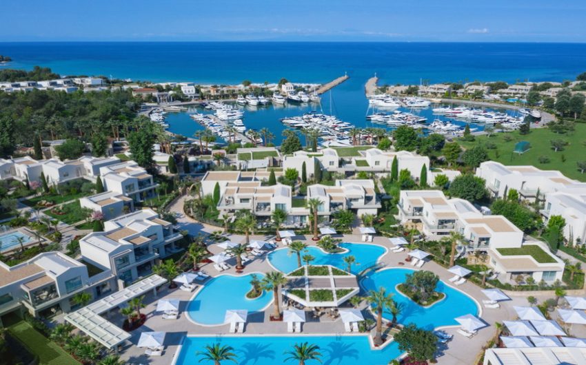 A luxurious resort with pools and a marina by the sea.