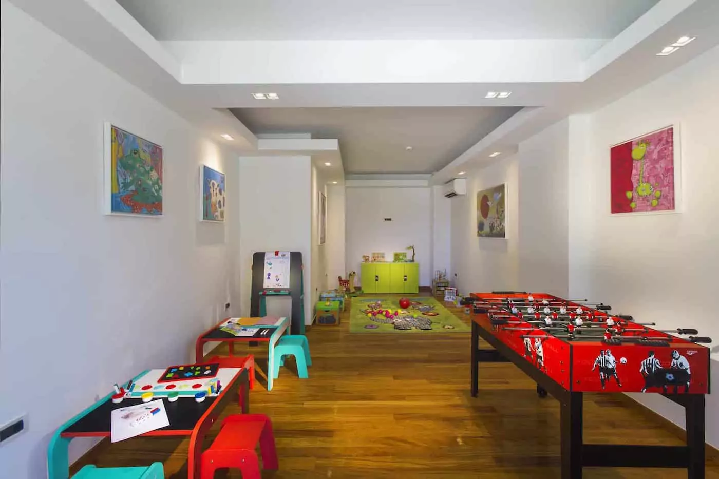 A colorful kids' playroom with toys and a foosball table.