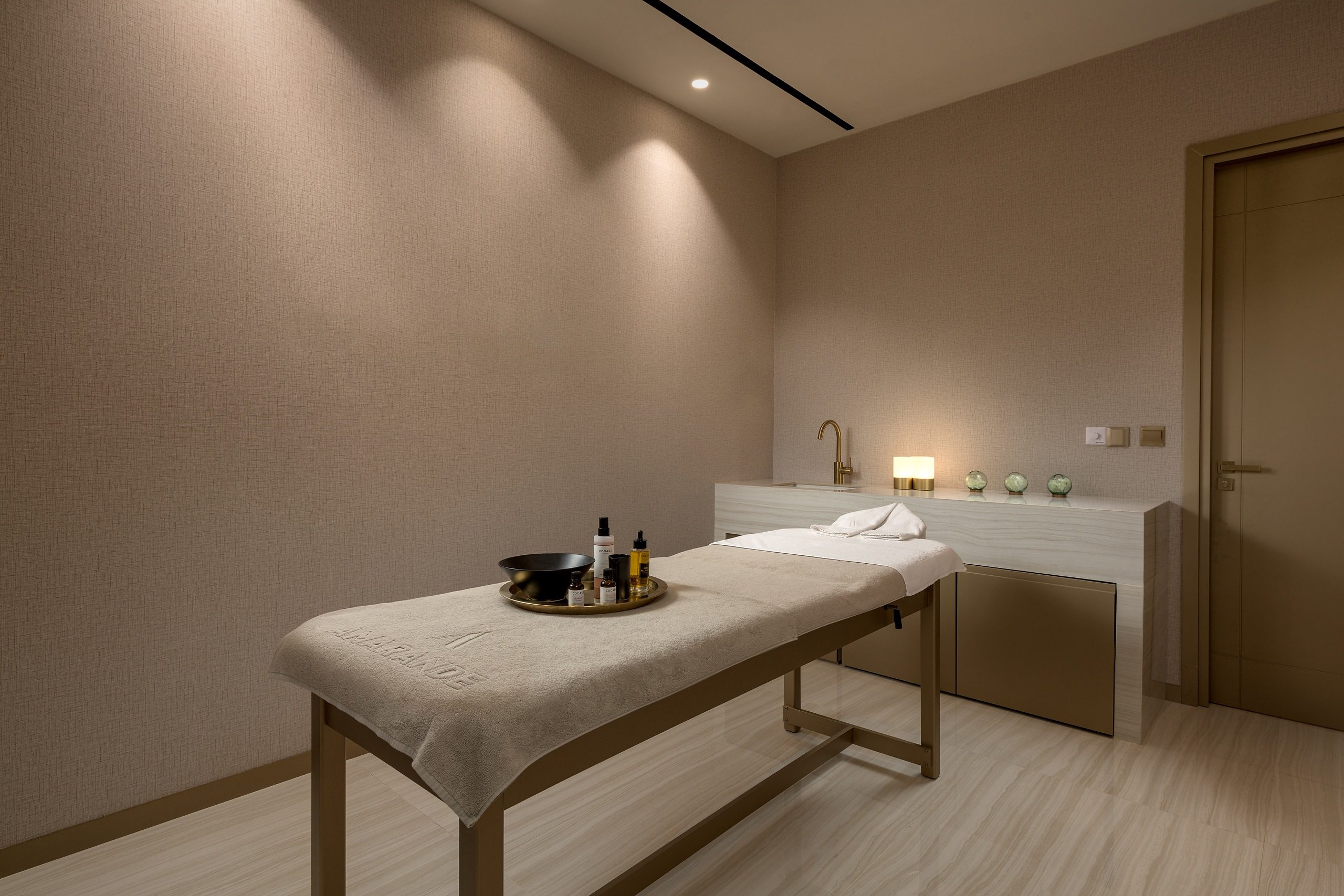 A serene spa room with a massage table and soft lighting.