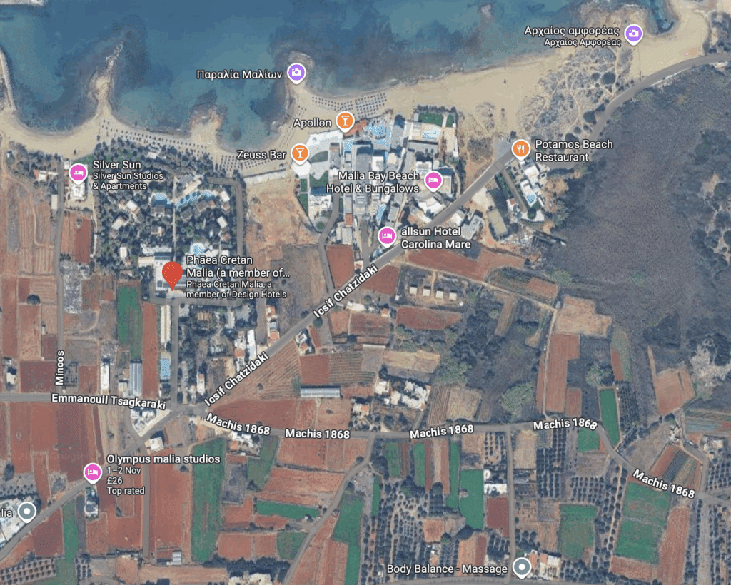 A coastal town with a beach, buildings, and farmland.