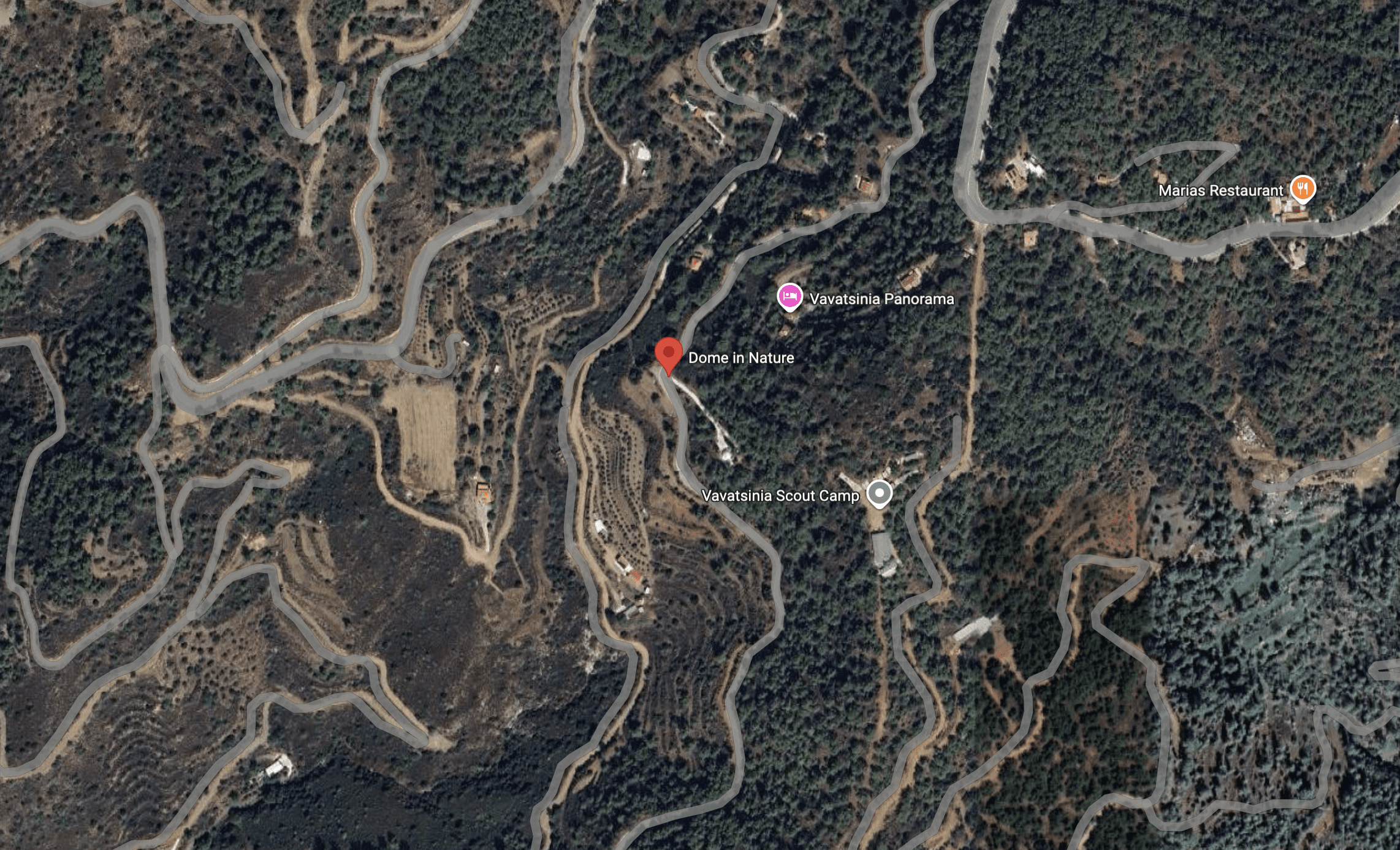 Aerial view of winding mountain roads surrounded by forest.