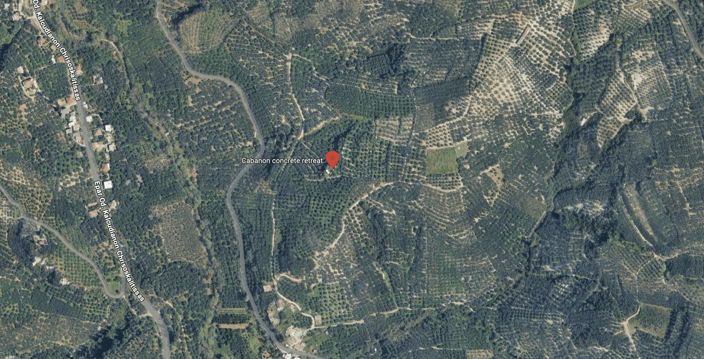 Aerial view of a forested area with scattered houses and roads.