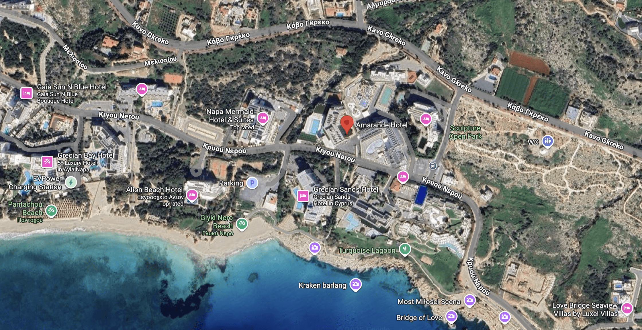Aerial view of a coastal resort with buildings, roads, and a beach.