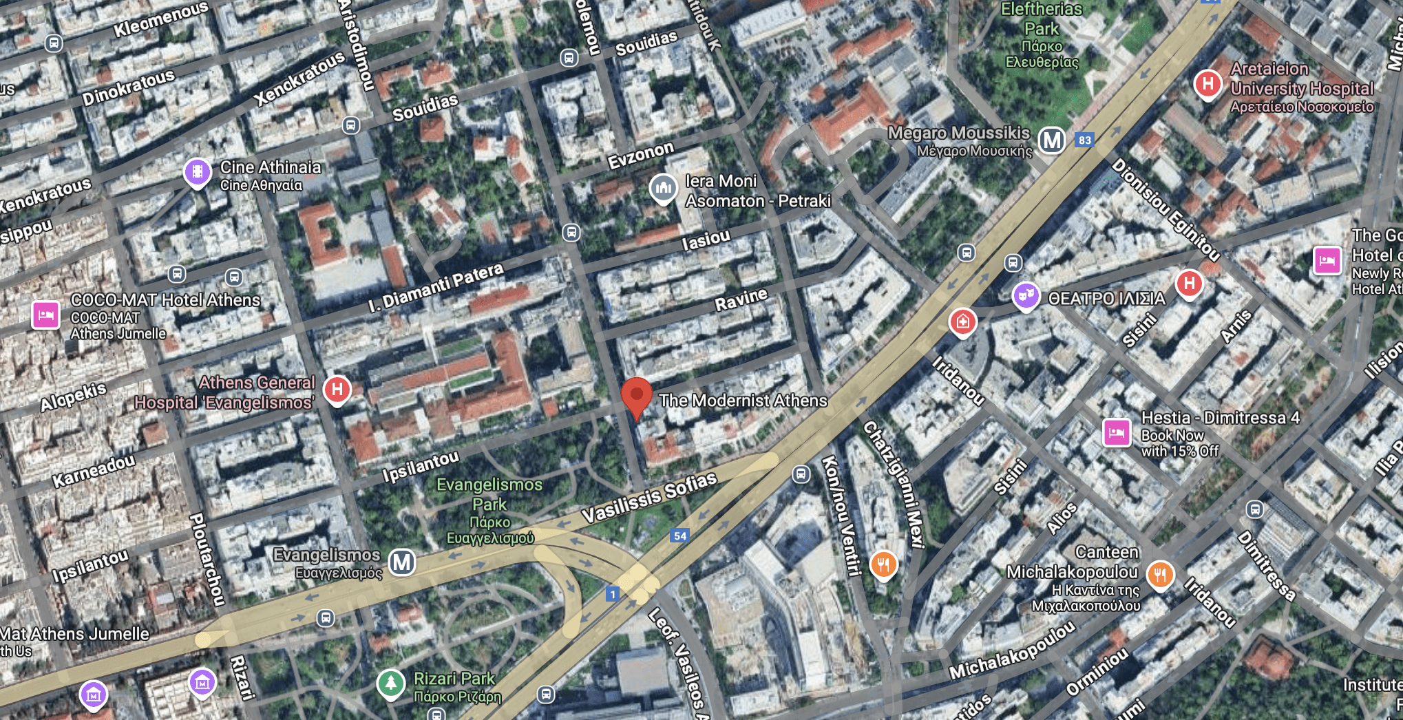 Aerial view of a city with roads, buildings, and greenery.