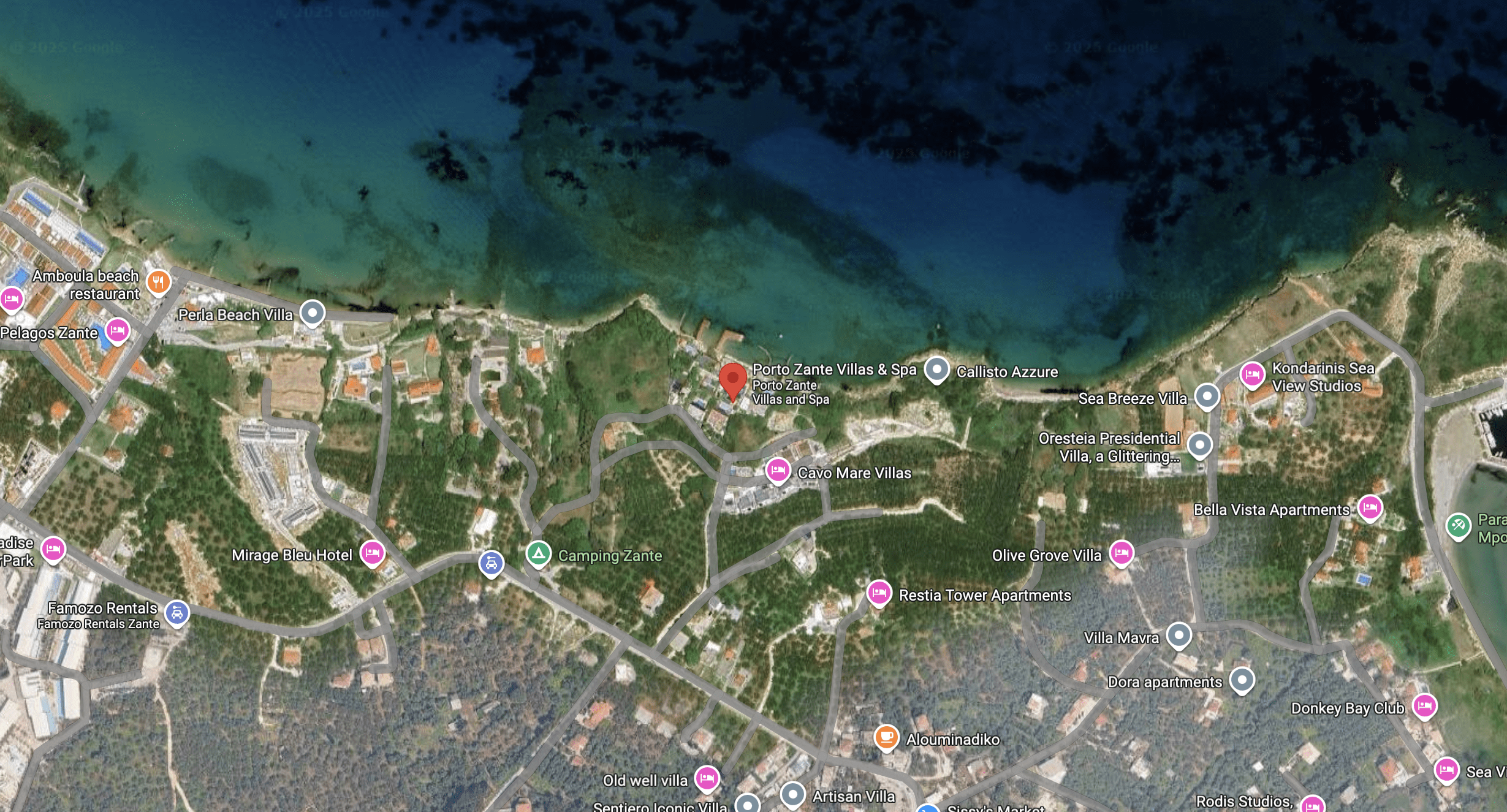 A coastal city area with roads and buildings near the sea.
