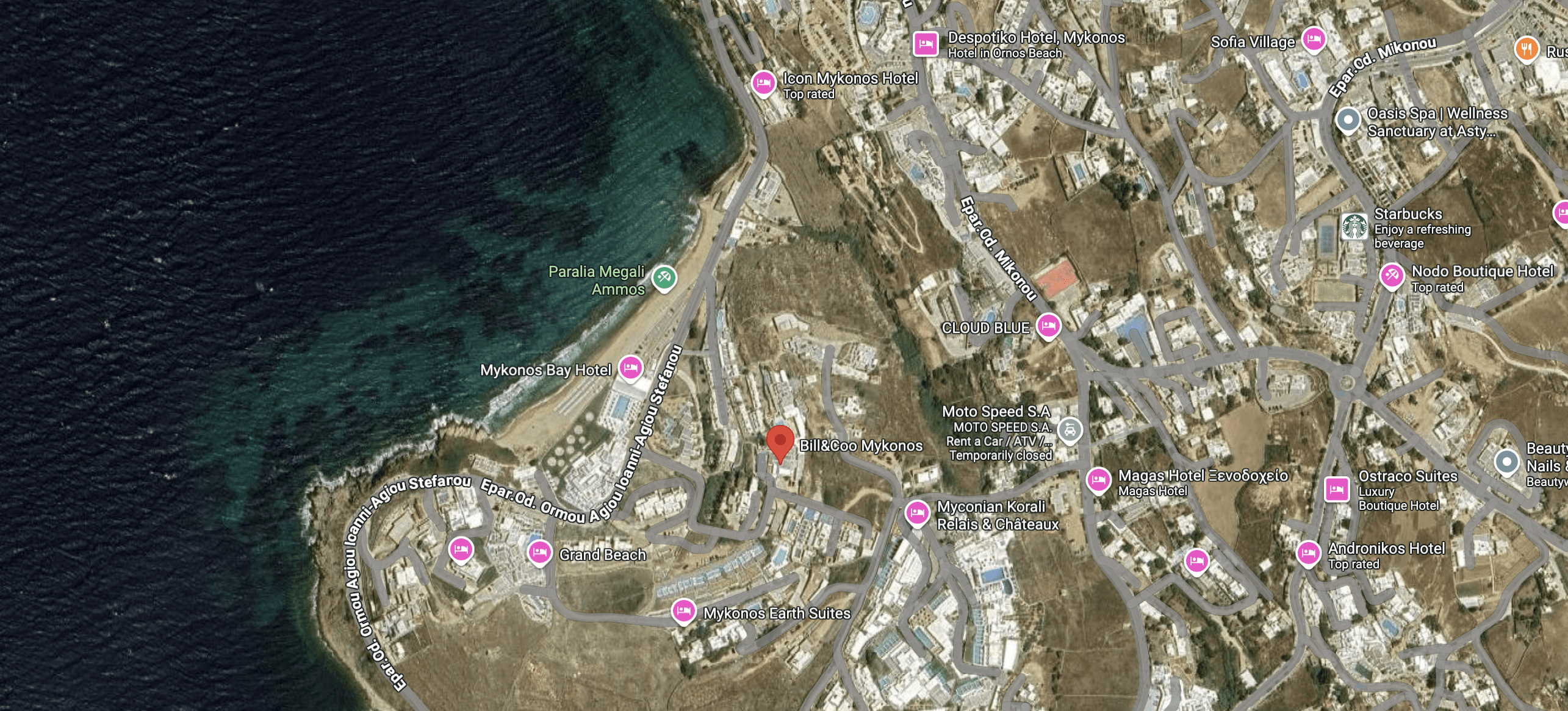 Aerial view of a coastal area with roads and buildings near the sea.