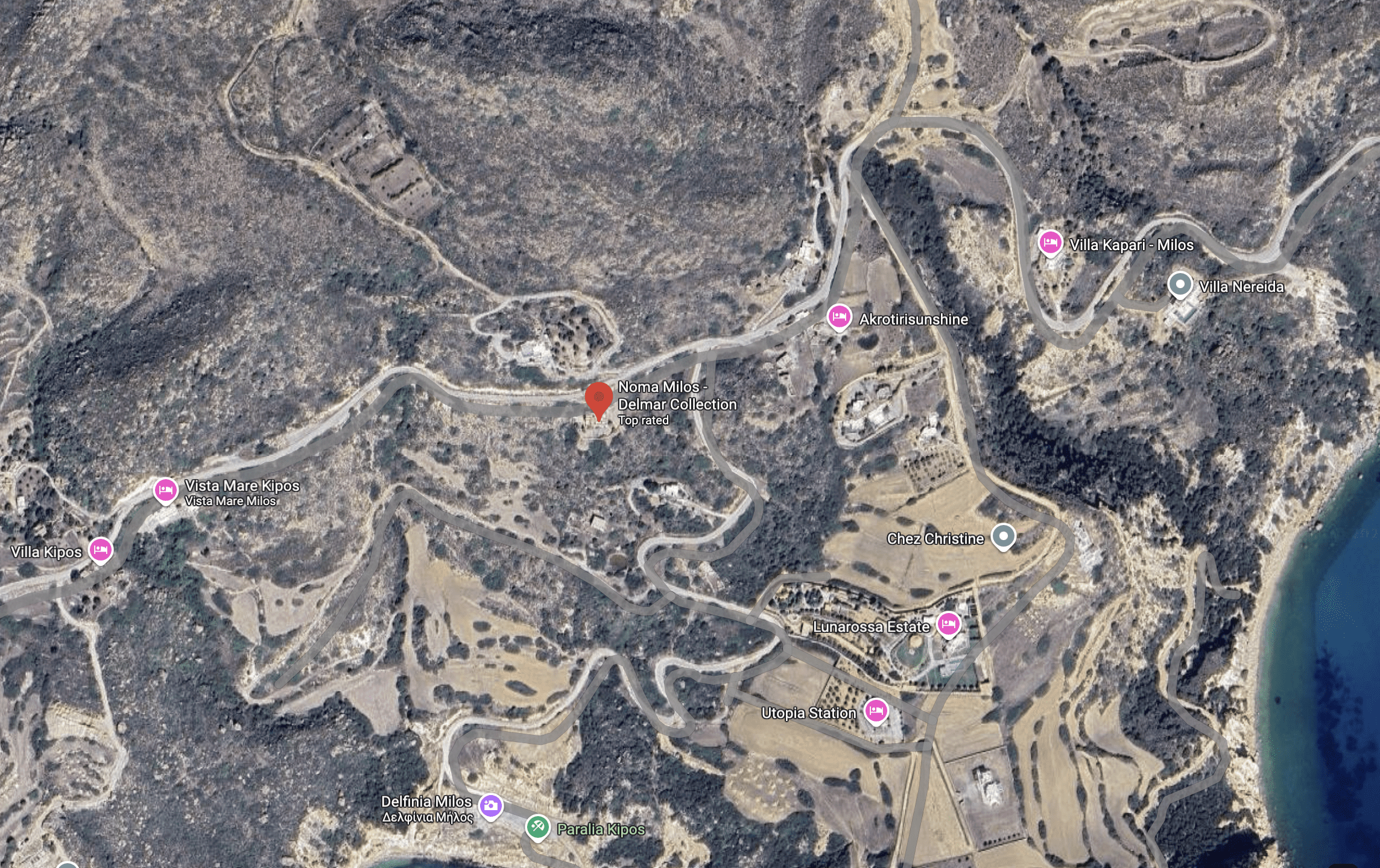 Aerial view of a mountainous rural area with winding roads and scattered buildings.