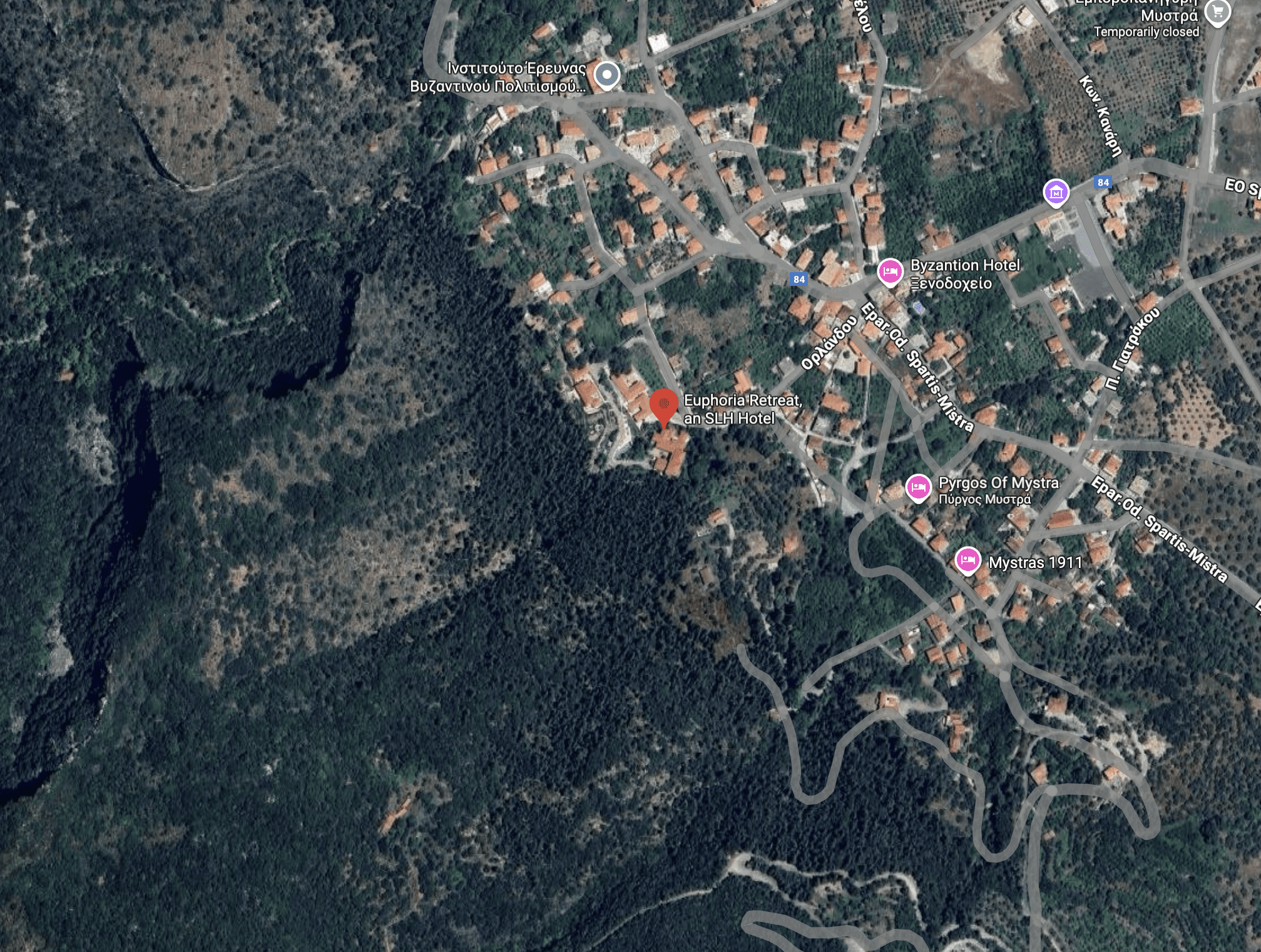 Aerial view of a small town with winding roads and dense forest.