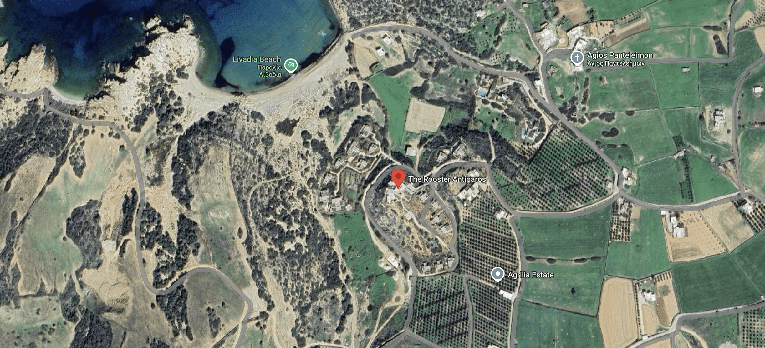Aerial view of a coastal area with fields, roads, and buildings.