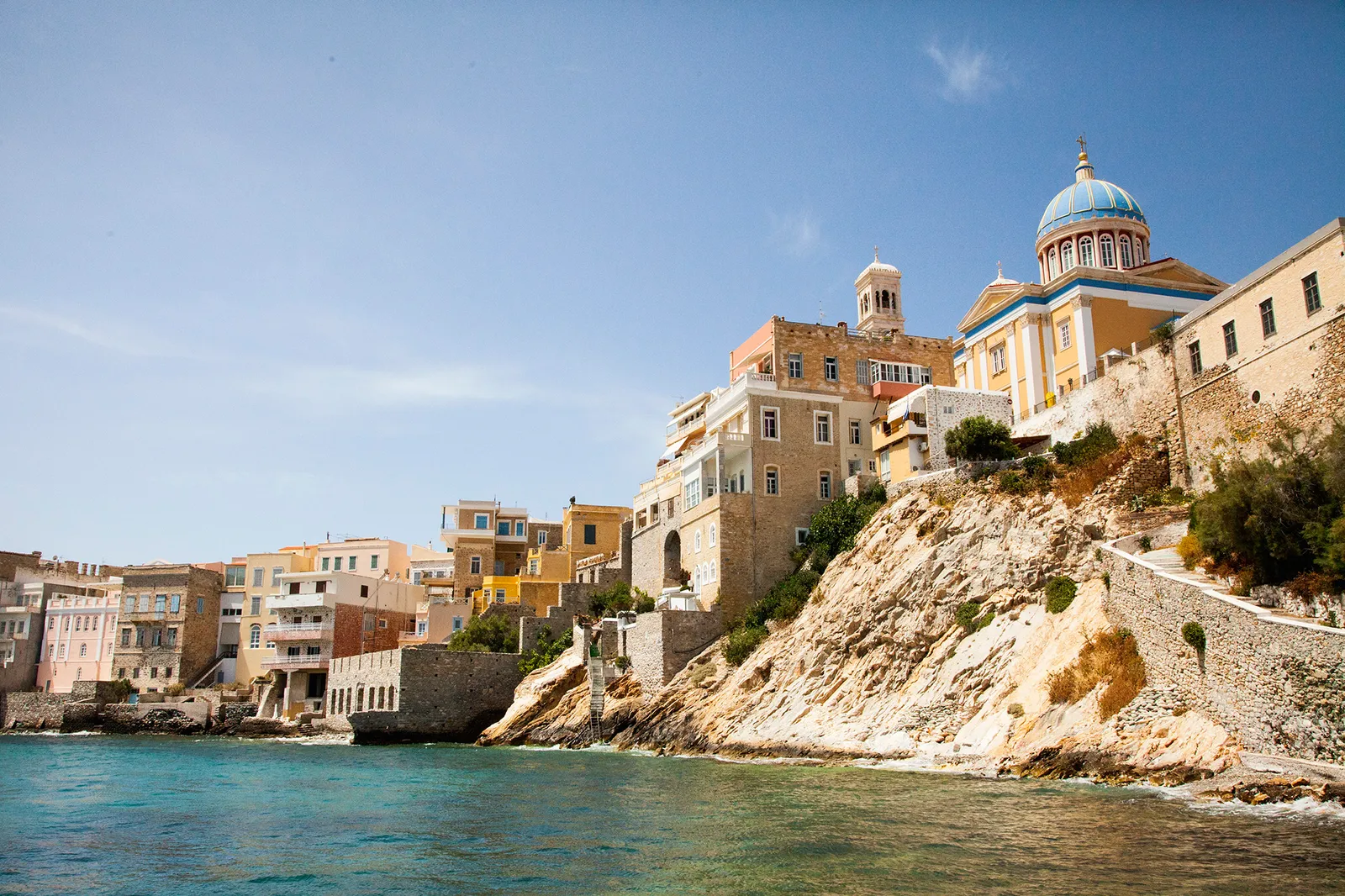 Mediterranean coastal town with historic buildings on cliffs.