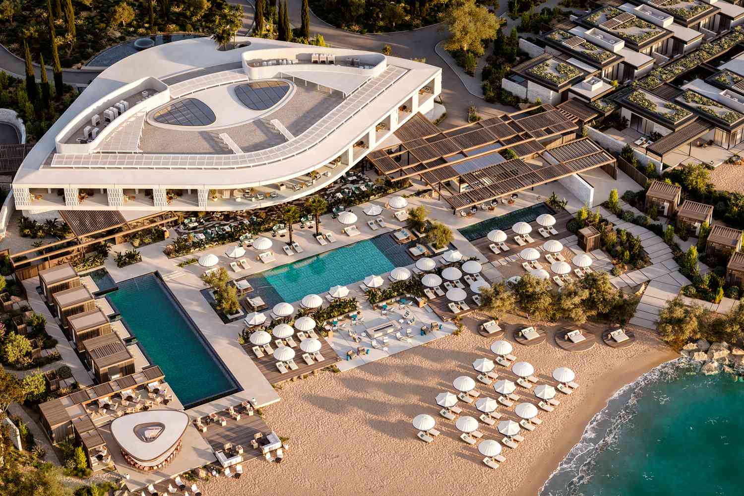 Aerial view of a luxurious beachfront resort with pools and sun loungers.