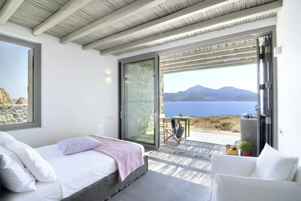 Bright bedroom with sea view and rustic decor.