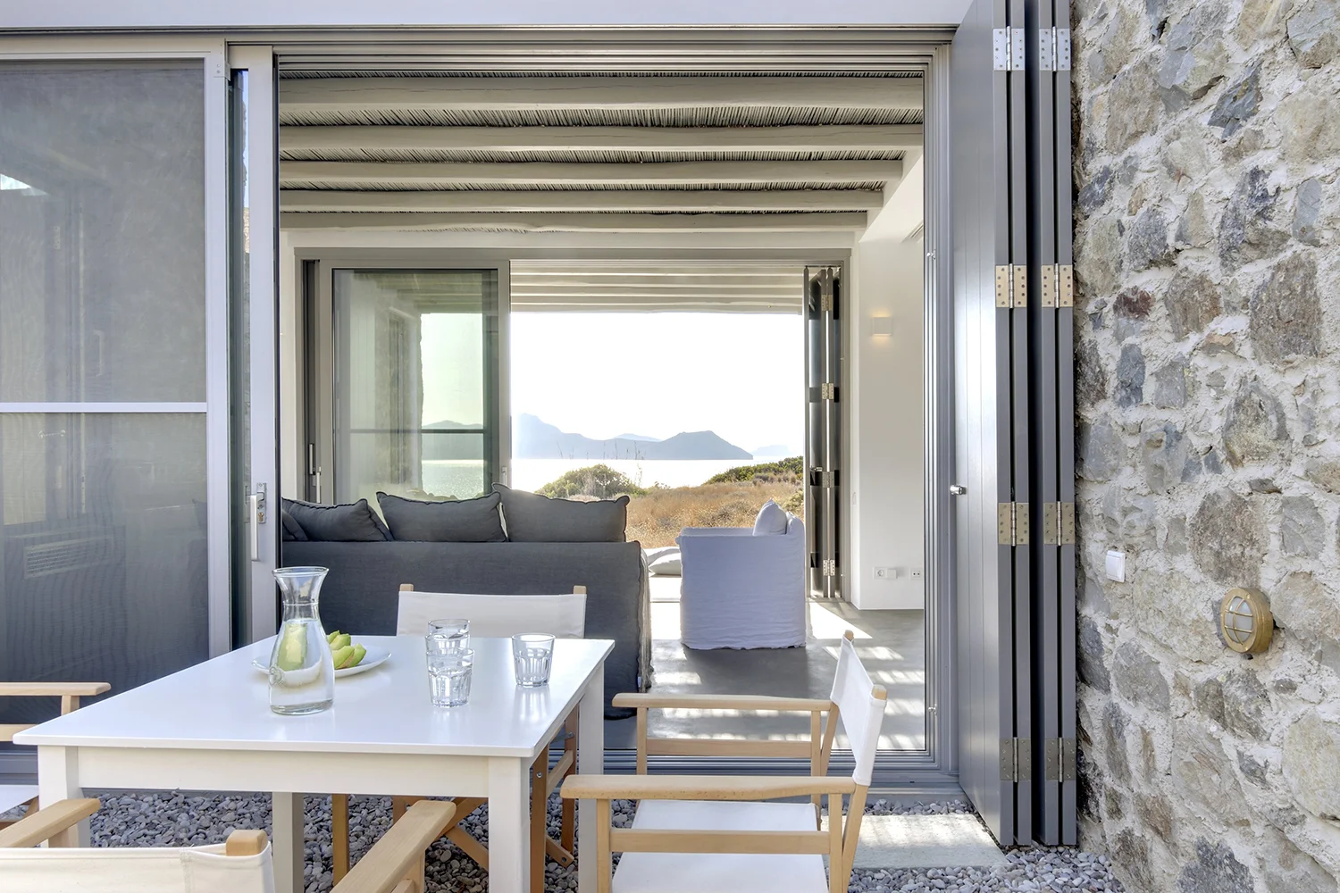 Modern outdoor seating area with ocean view and neutral tones.