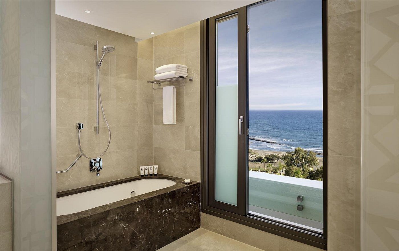Modern bathroom with sea view through a large window.