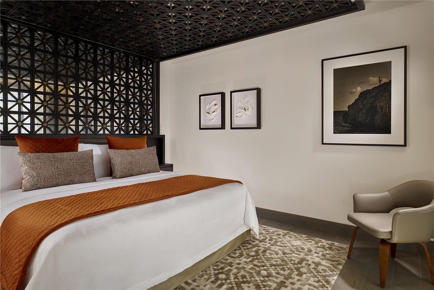 Modern hotel room with patterned wall and warm lighting.