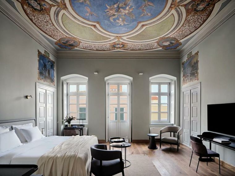 Elegant room with ornate ceiling and large windows.