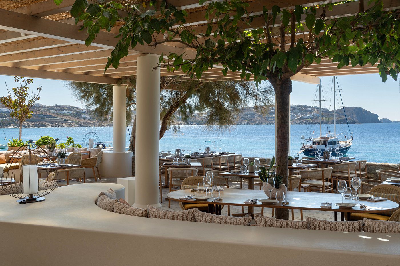 Refined open-air restaurant at Bill and Coo Mykonos with views of the Aegean Sea.