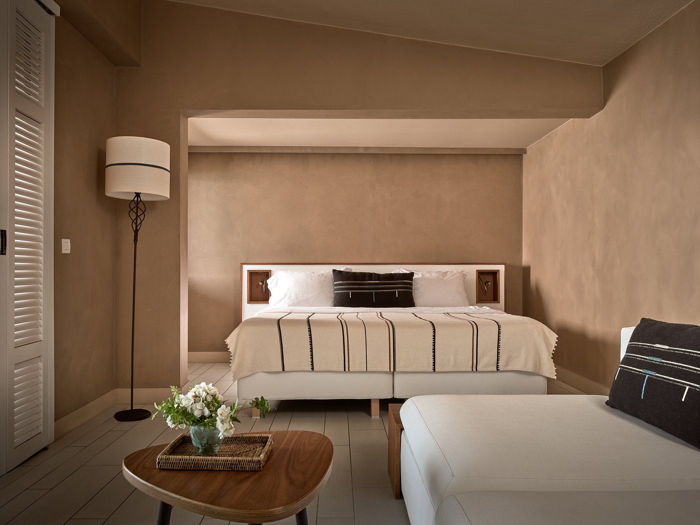 Minimalist bedroom with beige tones and modern furniture.