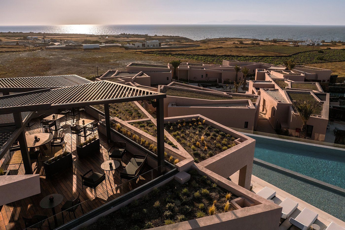 Scenic rooftop view overlooking a tranquil coastal landscape at sunset.