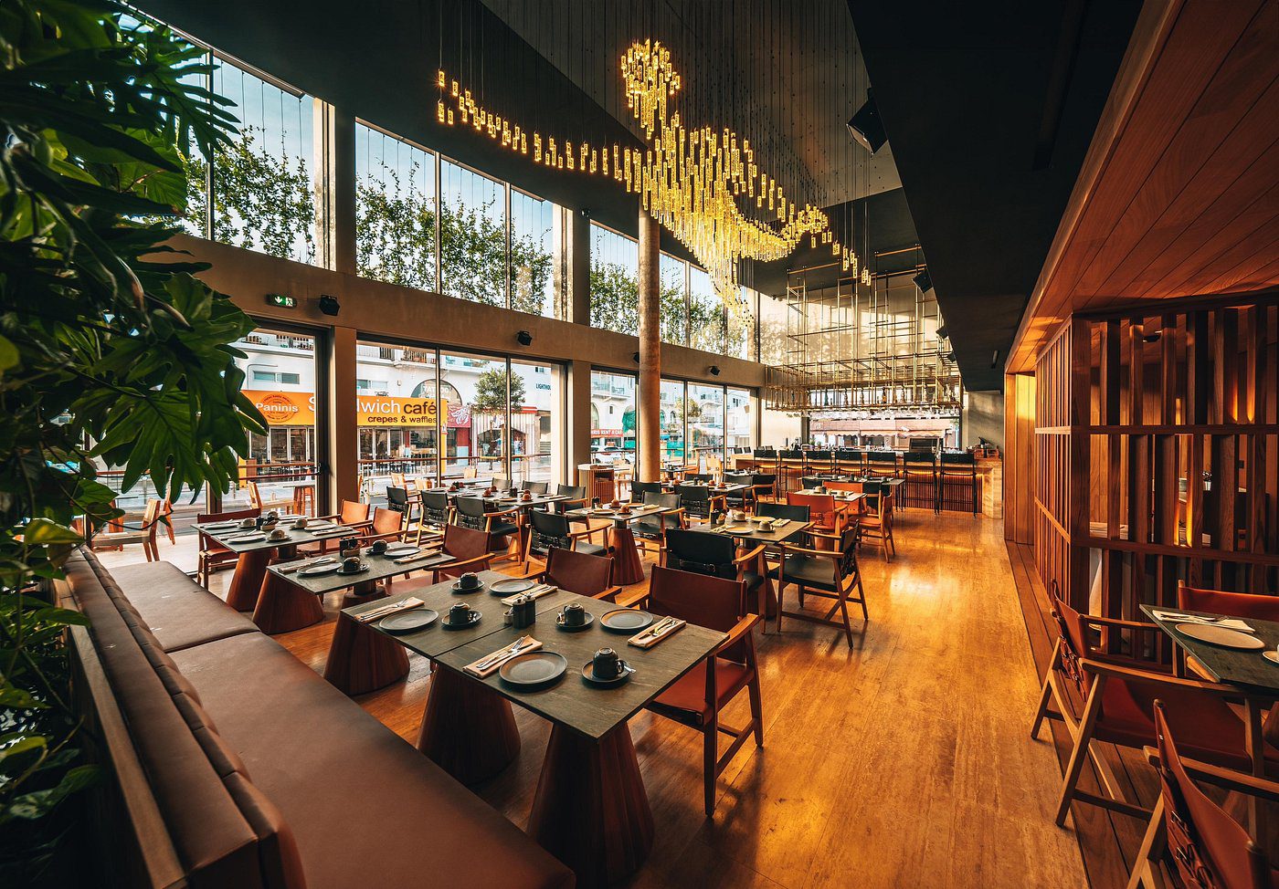 Elegant restaurant interior with large windows and modern lighting.