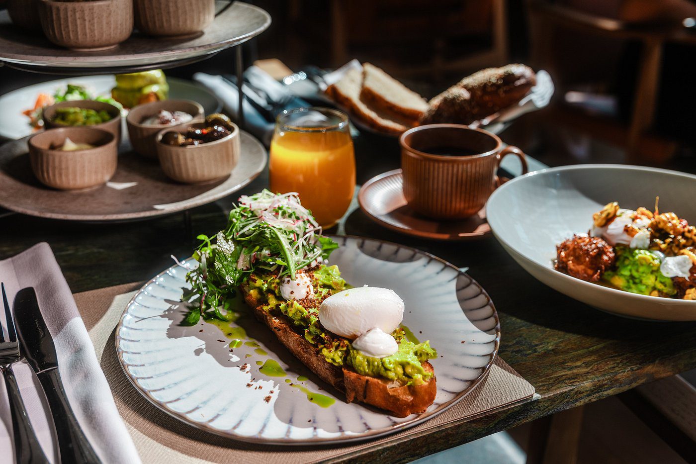 A gourmet avocado toast topped with poached eggs and microgreens.