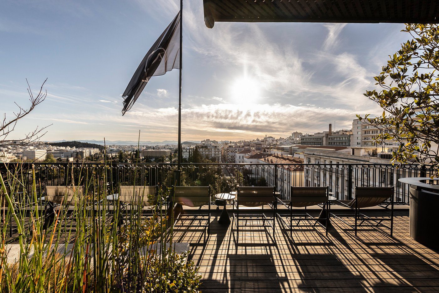 Scenic rooftop view with a flag and cityscape under a cloudy sky.