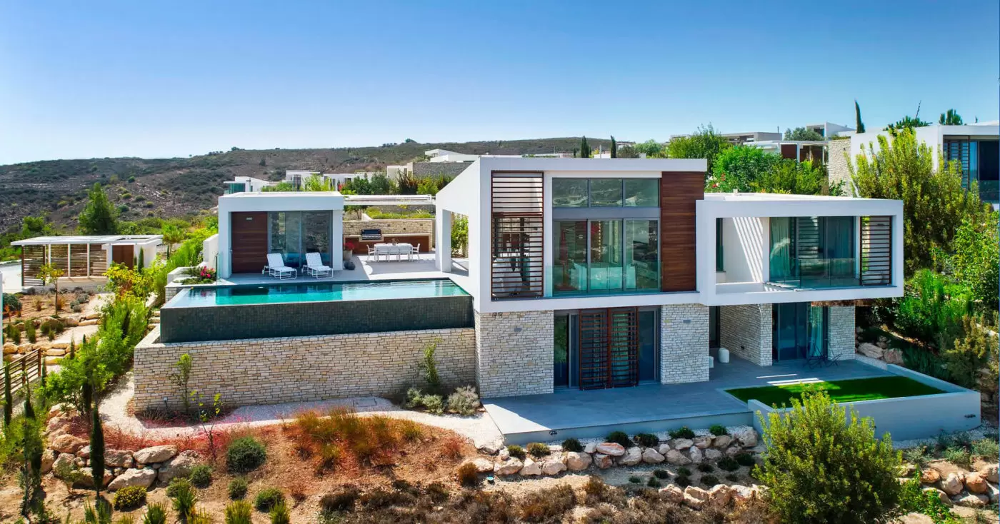 Modern luxury house with a pool and scenic hillside views.