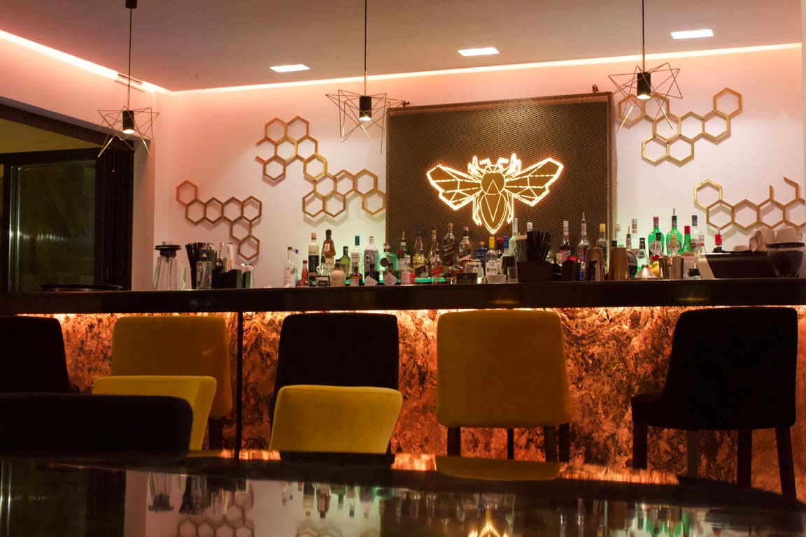 Cozy bar with honeycomb decor and warm lighting.