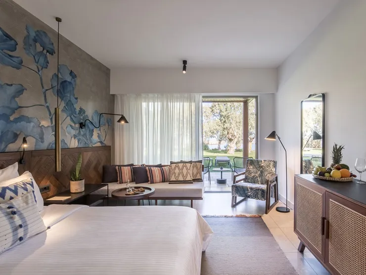 Modern hotel room with a cozy seating area and balcony.