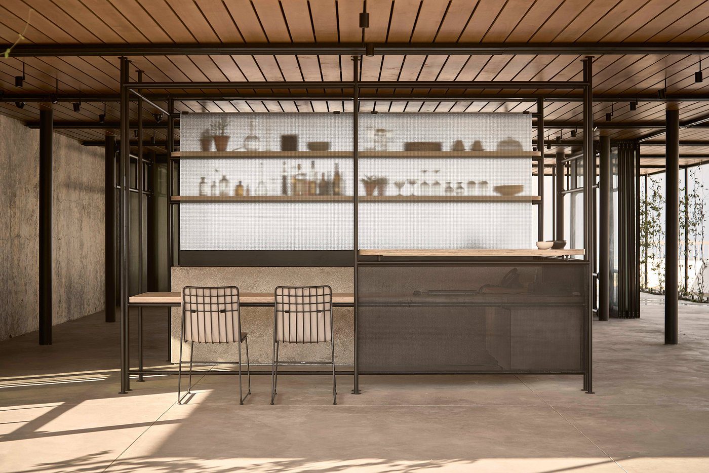 Minimalist café interior with metal chairs and shelves displaying ceramics.