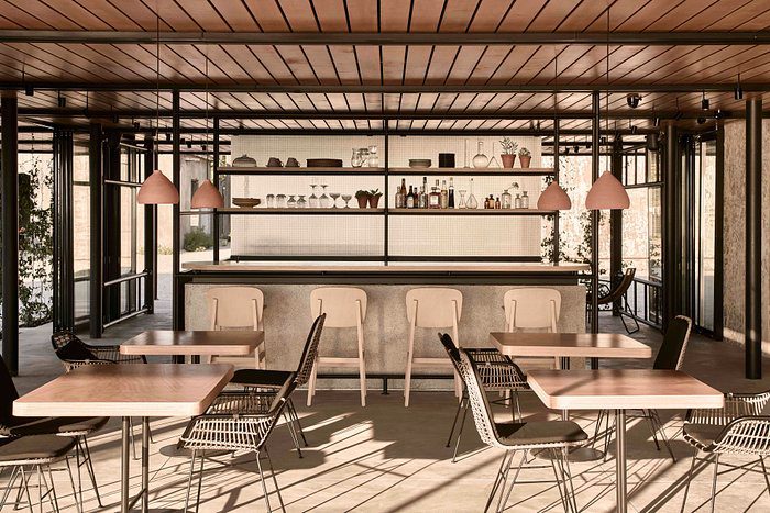 Modern cafe interior with wooden furniture and warm lighting.