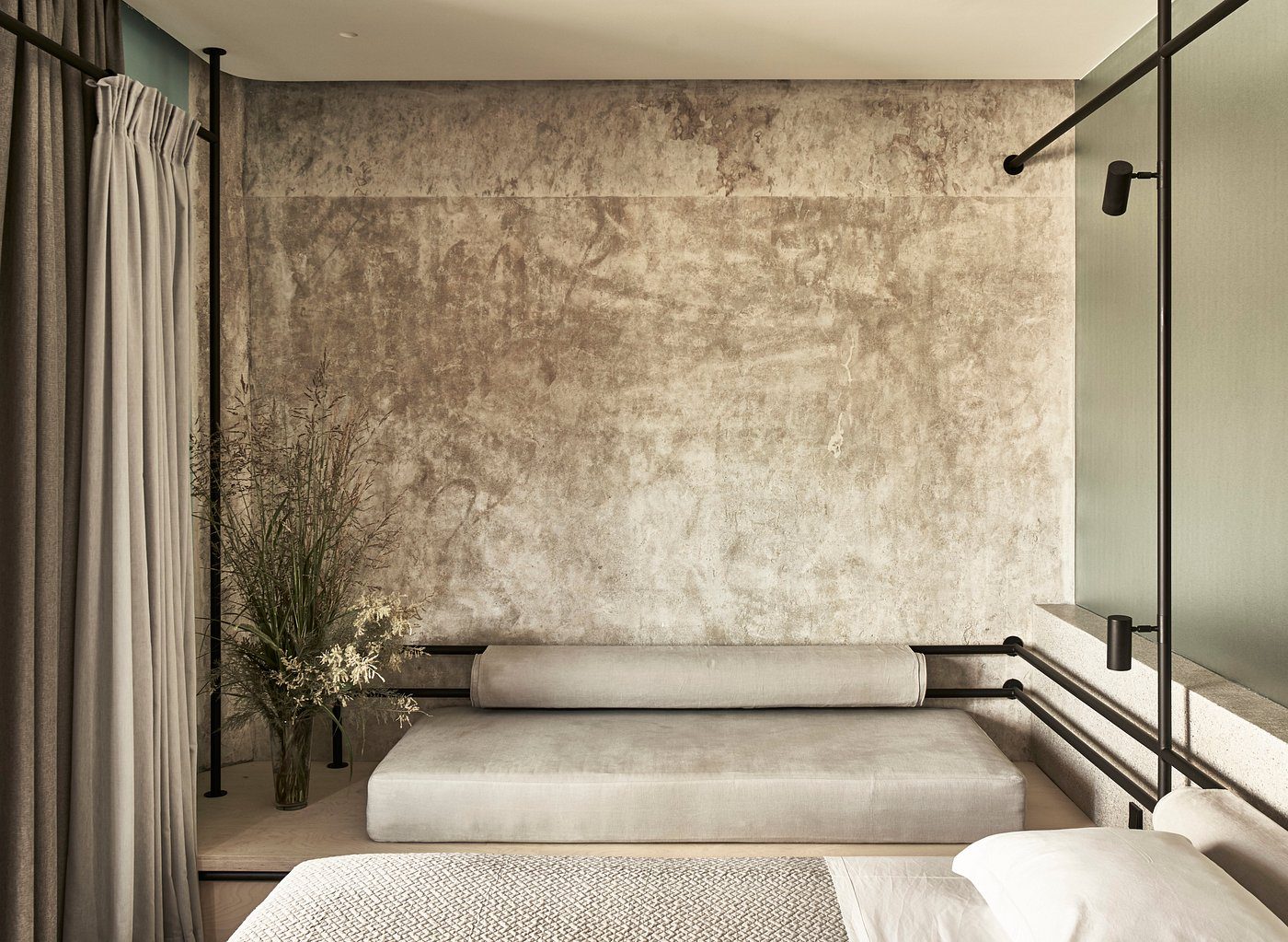 Minimalist beige room with textured wall and simple furniture.
