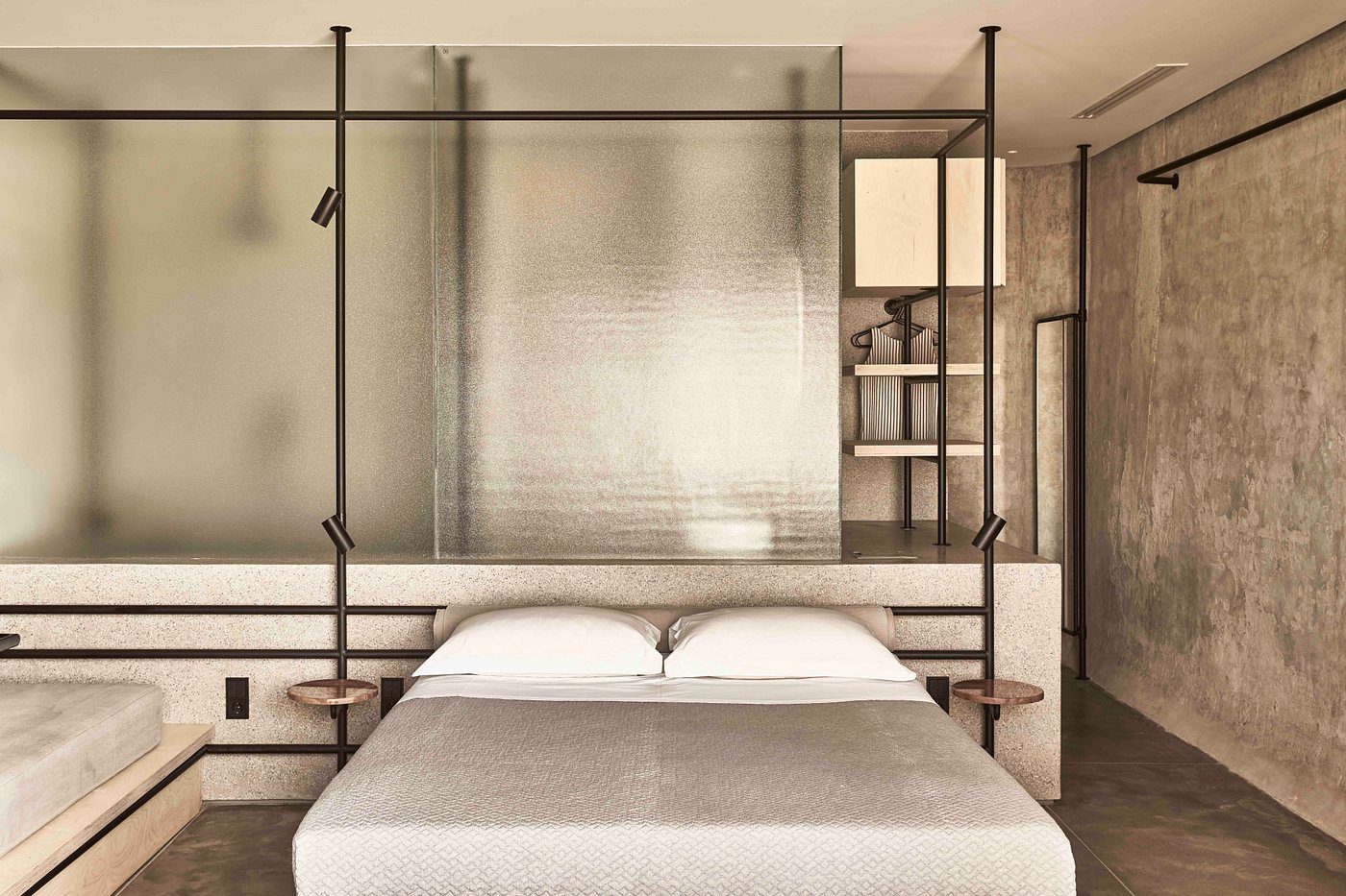 Minimalist bedroom with suspended shelves and a textured wall.