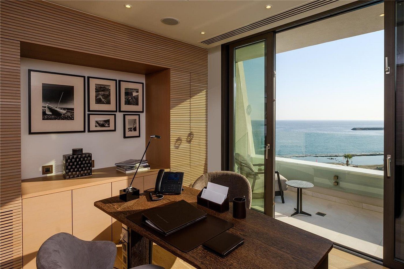Modern office with ocean view and minimalist decor.