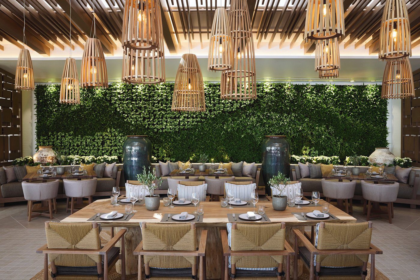 Elegant restaurant interior with wooden furniture and hanging lights.
