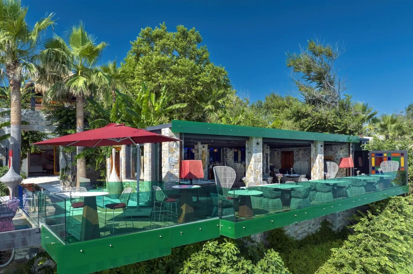 Modern vacation villa with a pool surrounded by lush greenery.