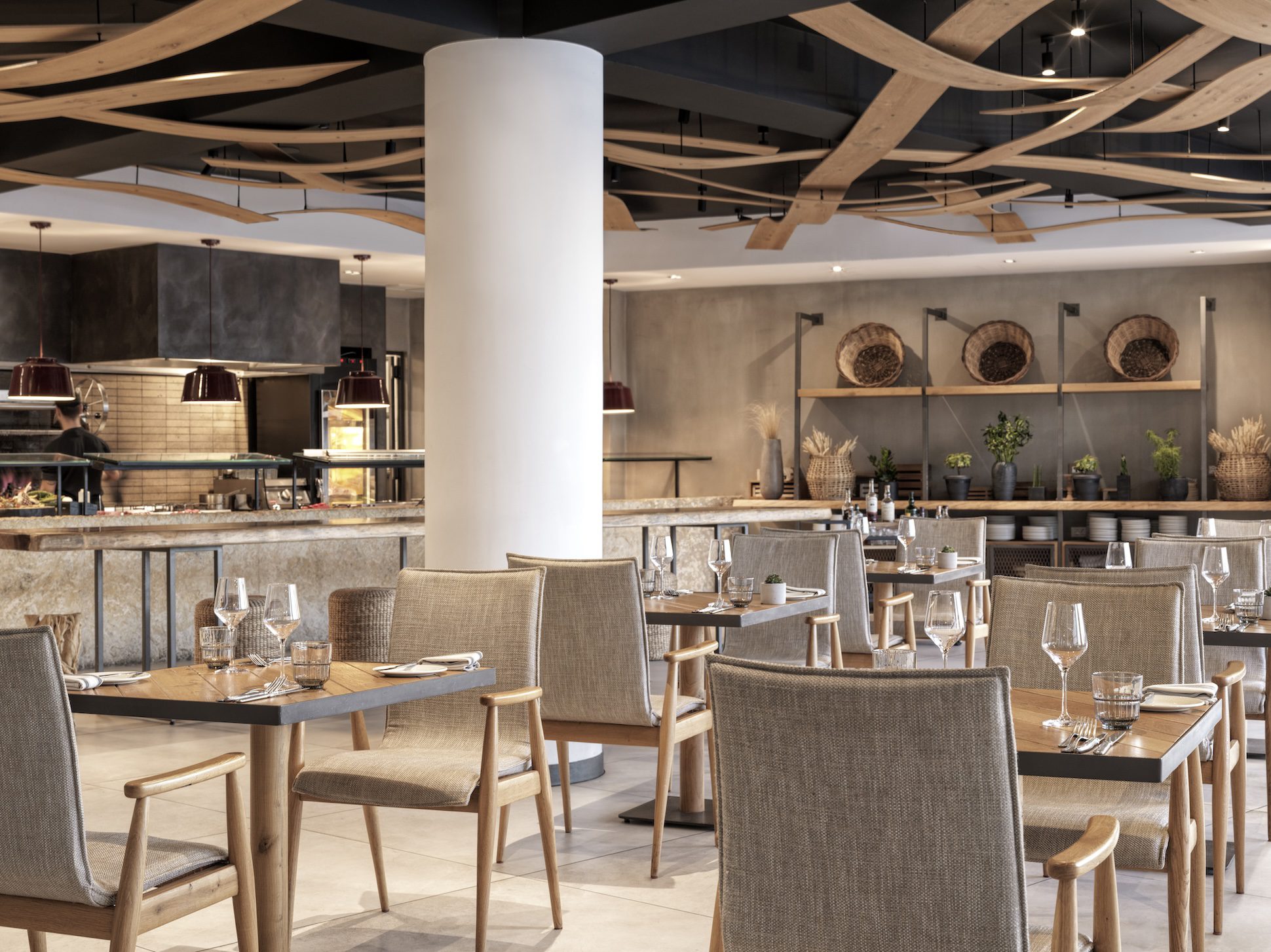 Elegant, modern restaurant interior with wooden chairs and soft lighting.
