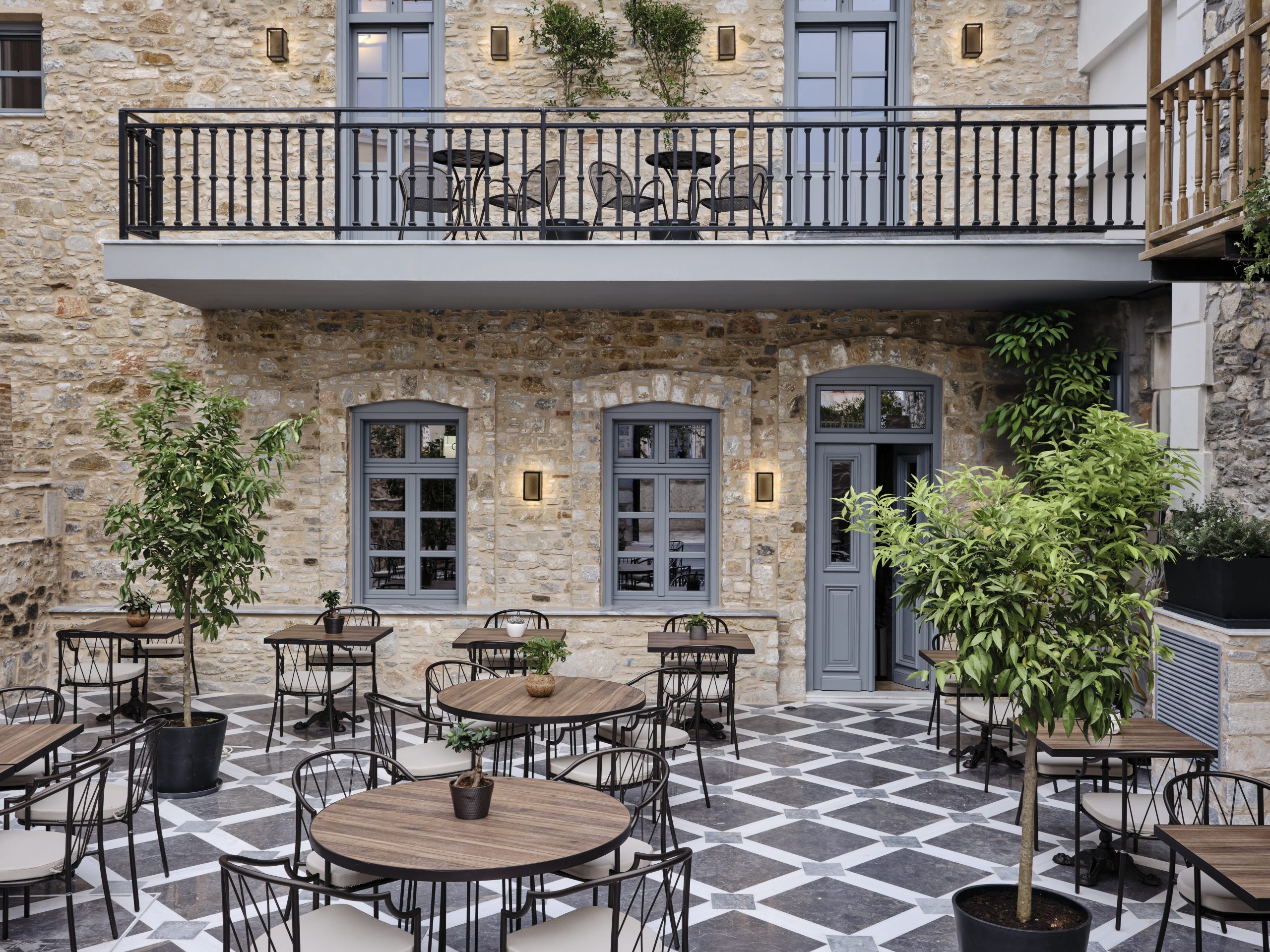 Cozy outdoor patio with round tables and chairs under soft lighting.